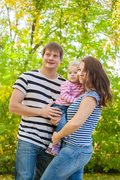 Mom dad and daughter in their arms for a walk in the woods