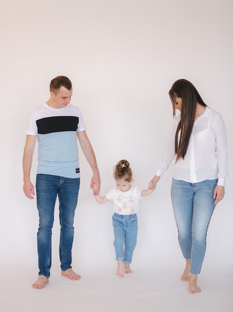 Mamma papà e figlia che camminano in studio