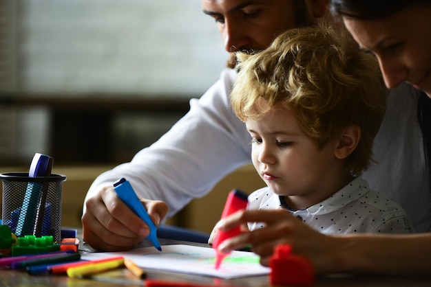 Foto mamma e papà disegno con bambino giovani genitori felici mamma papà con bambino giorno della famiglia genitorialità infanzia concetto infanzia apprendimento bambini abilità artistiche