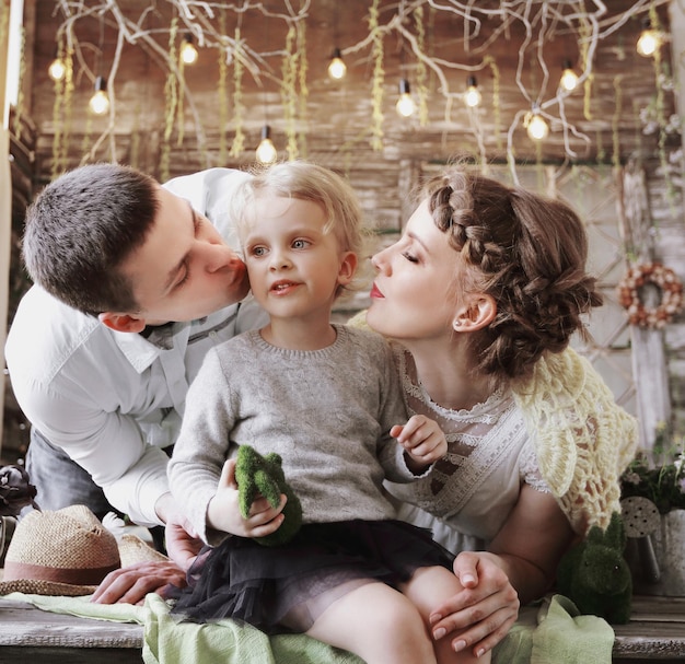 ママとパパは彼の小さな娘にキスします