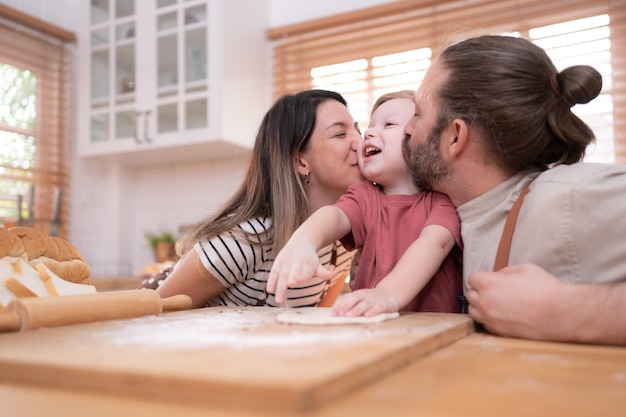 Mom and dad in the kitchen of the house with their small children Have a good time baking bread and making dinner together