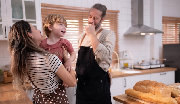 Mom and dad in the kitchen of the house with their small children Have a good time making dinner