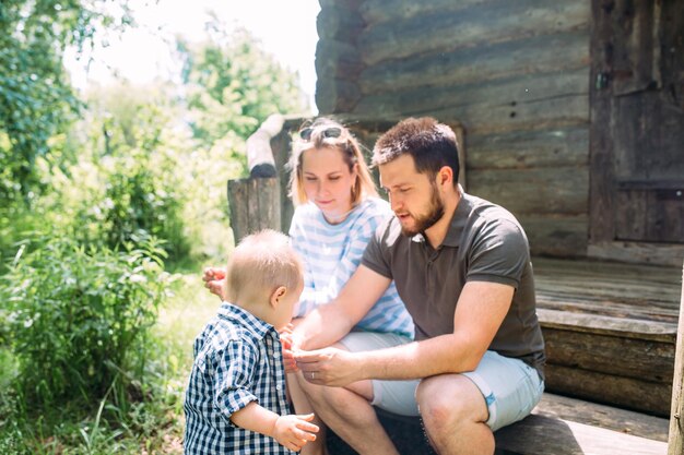 Mom dad and little son spend time together in the summer outdoors