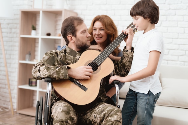 Mom dad and son singing with a guitar.