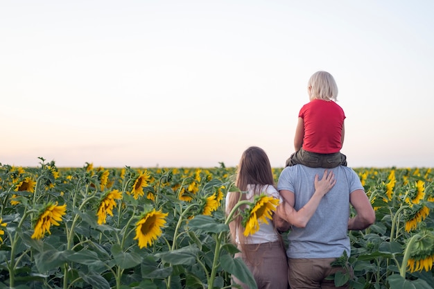 Mom, dad and son on sunflower field