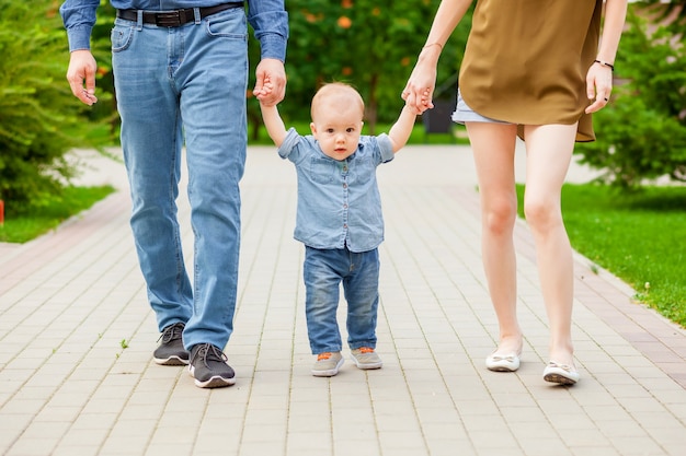 Mom and dad walk with the baby in the Park