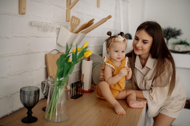 Mom and daughter are hugging in the kitchen Family life at home