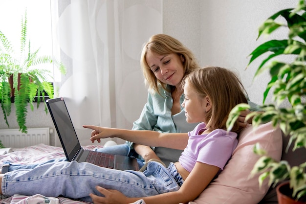 mom and daughter are looking at a laptop