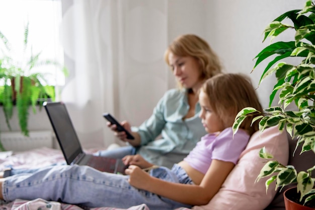 mom and daughter are looking at a laptop