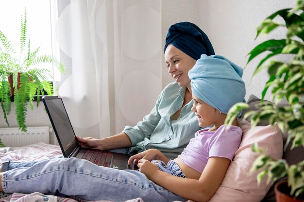 mom and daughter are looking at a laptop