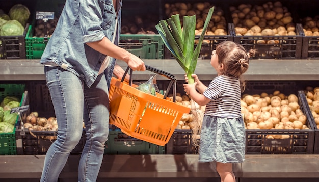 mom and daughter are shopping at the supermarket