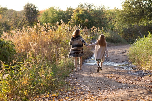 Mamma e figlia stanno camminando al tramonto. natura