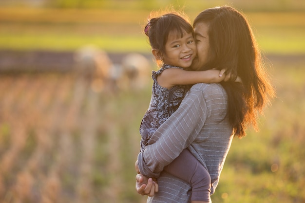 Mom and daughter in beautiful sunset scenery