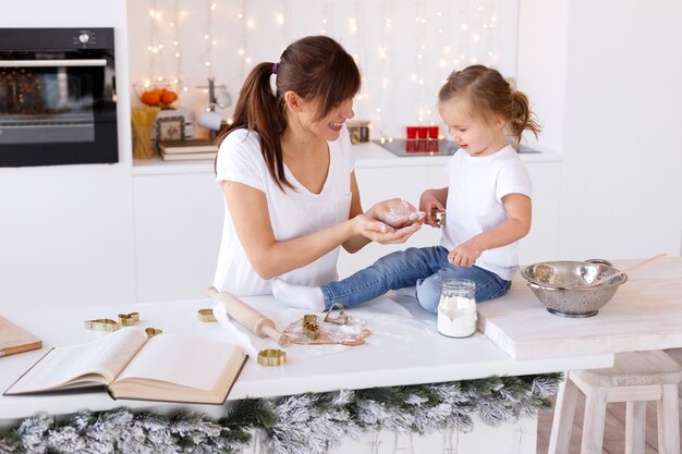 Mom and daughter cook in a light kitchen at home