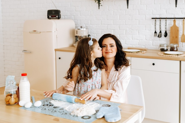 Mom and daughter cook together in the kitchen.