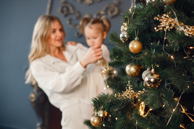 Mom and daughter decorating Christmas tree together