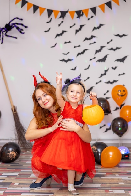 Mom and daughter in devil costumes at home halloween party