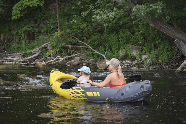 Photo mom and daughter go kayaking on the river in the summer high quality photo