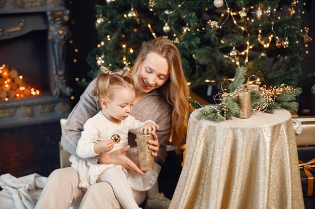 Mom and daughter hugging near Christmas tree