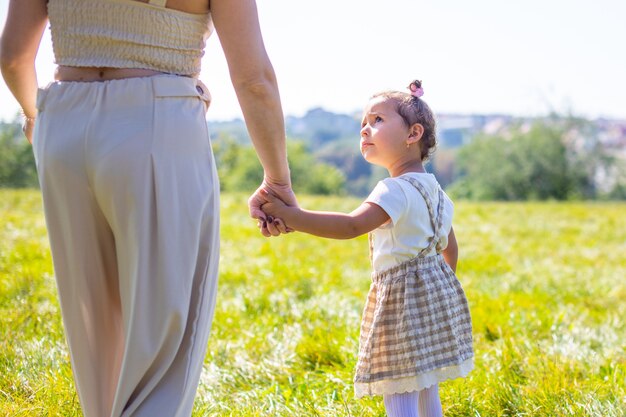 Mom and daughter laughing and having fun in the park the concept of a happy family friendship and love