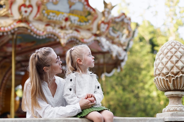 Mom and daughter look up in summer on a walk