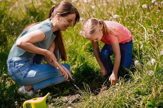 Mom and daughter looking busy while digging holes for planting