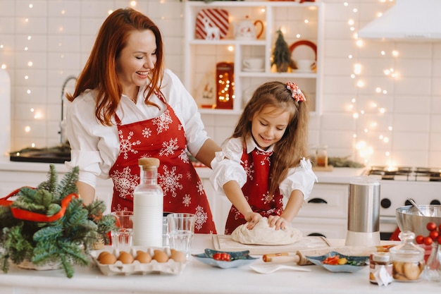 Mom and daughter in the New Year's kitchen together prepare dough for Christmas cookies