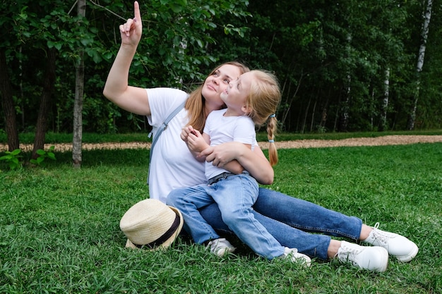 Mom and daughter in the park on the grass