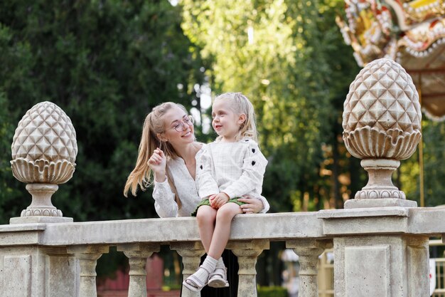 Mom and daughter in the park in the summer smile