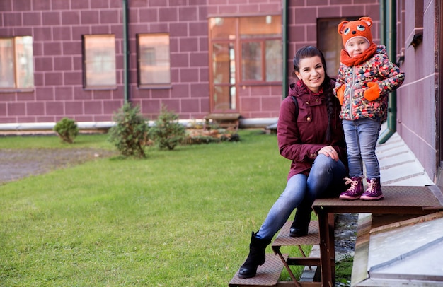 Mom and daughter on the porch in autumn weather