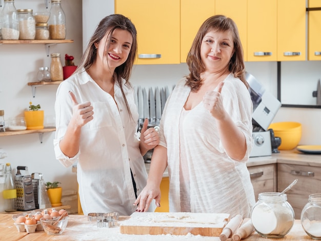 Mom and daughter posing in family kitchen