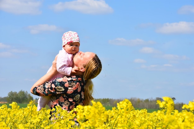 Mom and daughter in rapeseed blooming field