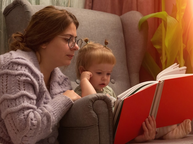 ママと娘が椅子のライフスタイルで本を読む