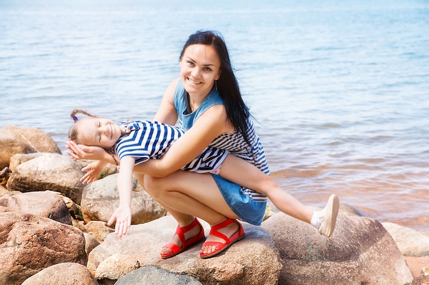 Photo mom and daughter relaxing by the lake