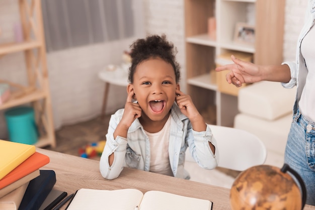 Mom and daughter together do their homework in school.