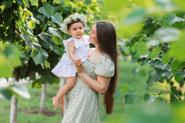 mom and daughter on a walk in the woods in the summer