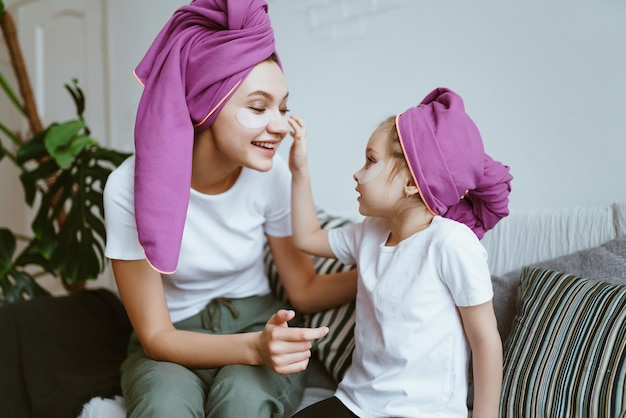 Mom and daughter washed their hair and shook their heads in towels