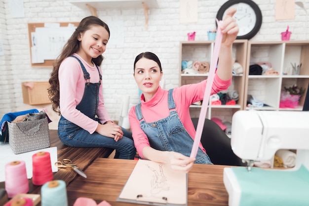 Foto mamma e figlia lavorano insieme nel laboratorio di cucito