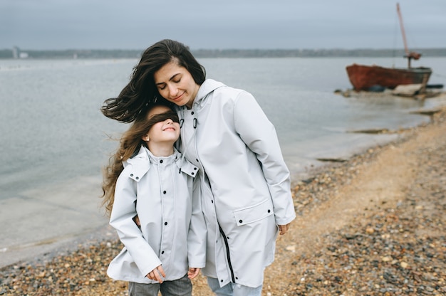 mom and dauther  have a fun on a boat background near the lake