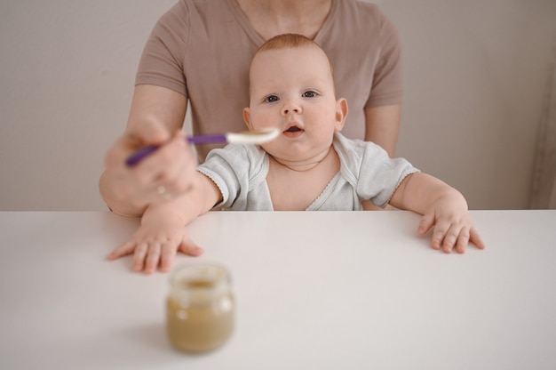 Mom feeding puree to a newborn.