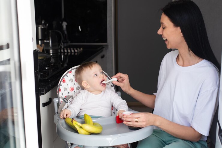 Mom feeds baby healthy food for small children maternity leave
