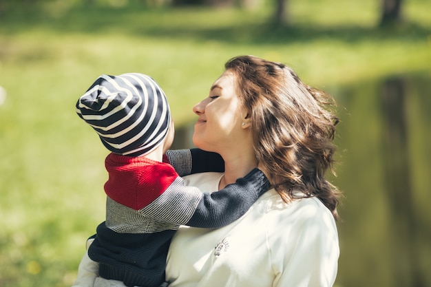 写真 ママは息子を優しく抱きしめます。ママは夏に息子と公園を散歩します。