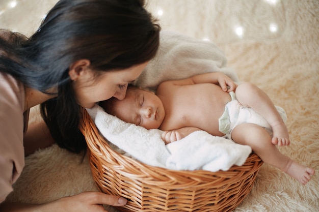 Mom gently looks at her sleeping newborn baby