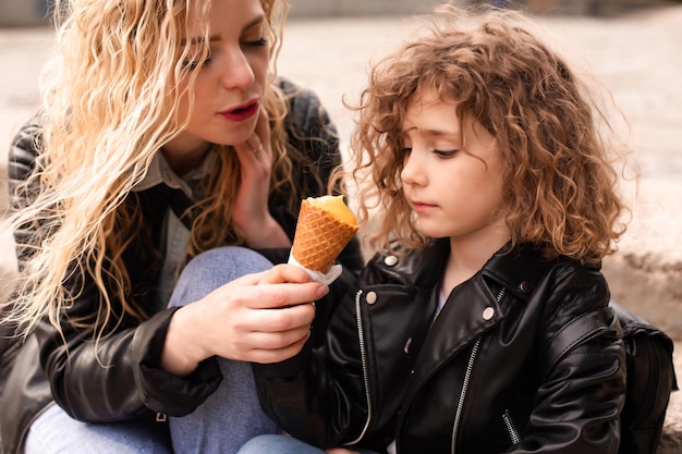 The mom gives her daughter a try ice cream