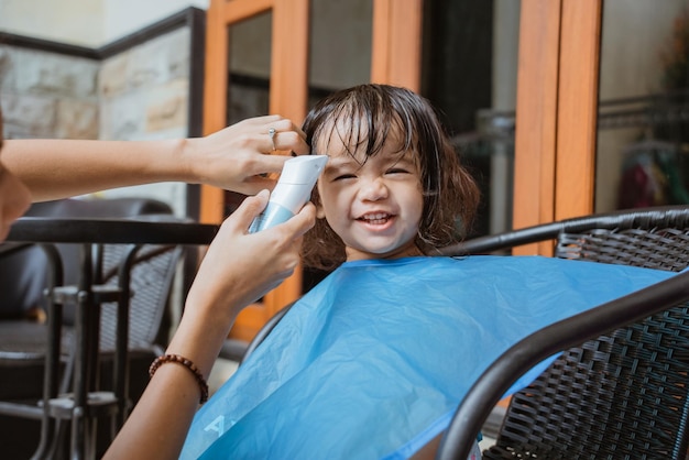 Mom having her daughter a haircut at home