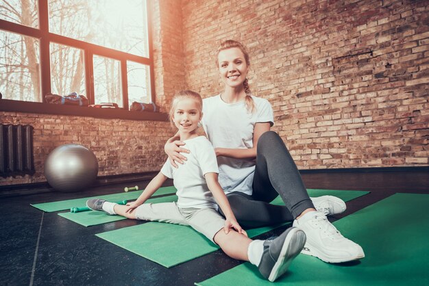 Mom Helps Daughter To Sit On Twine In The Gym.