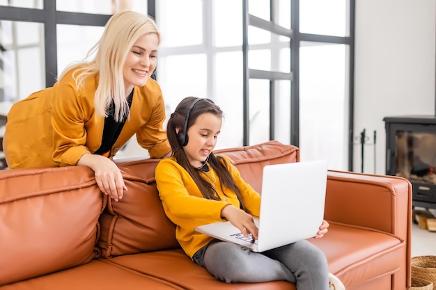 Mom helps her daughter with online homework. Distant education concept. View from the top.