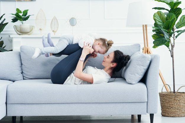 Mom and her daughter lying on the couch in the living room.