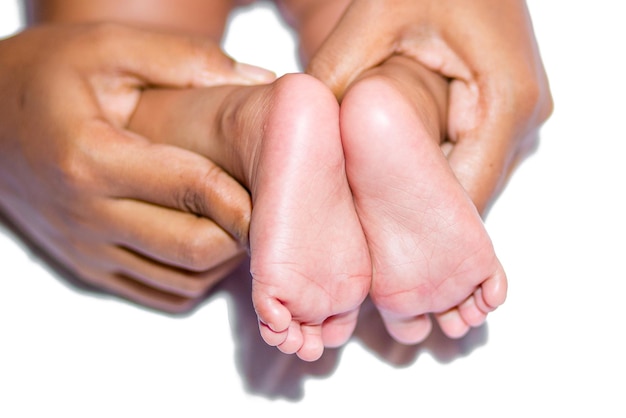 A mom holding baby's two feet on a white background