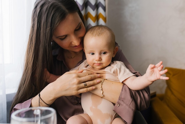 Photo mom holds baby in wet bodysuit